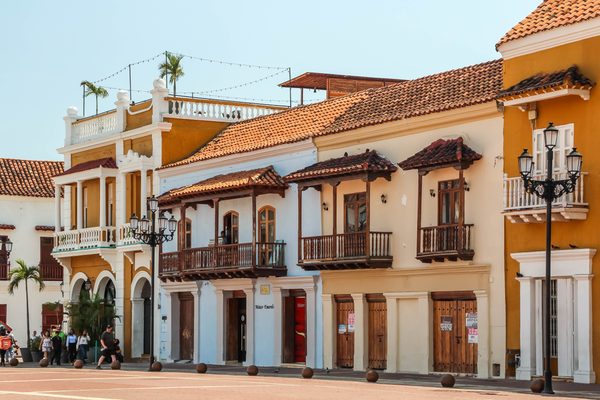 Colorful colonial buildings with wooden balconies on Plaza de la Aduana in Cartagena's walled city