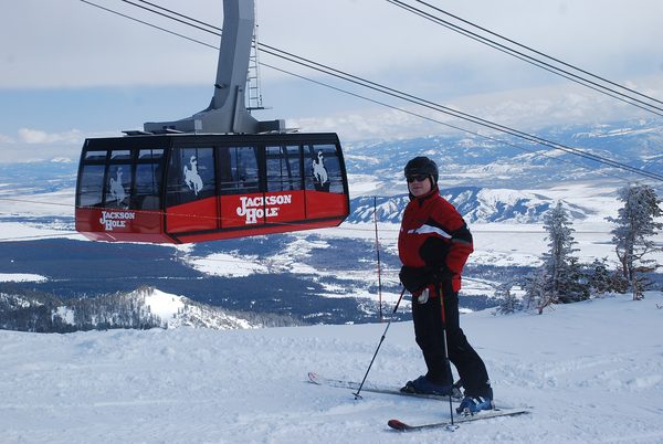 A skier beside the red Aerial Tram at Jackson Hole Mountain Resort
